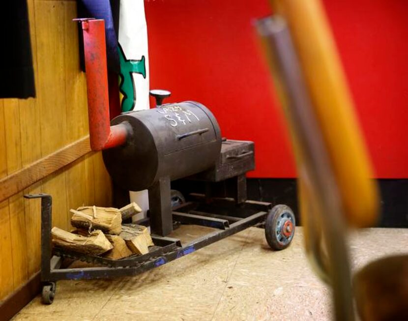 
A mini smoker is parked next to a booth inside Lazy S&M BBQ in Joshua.
