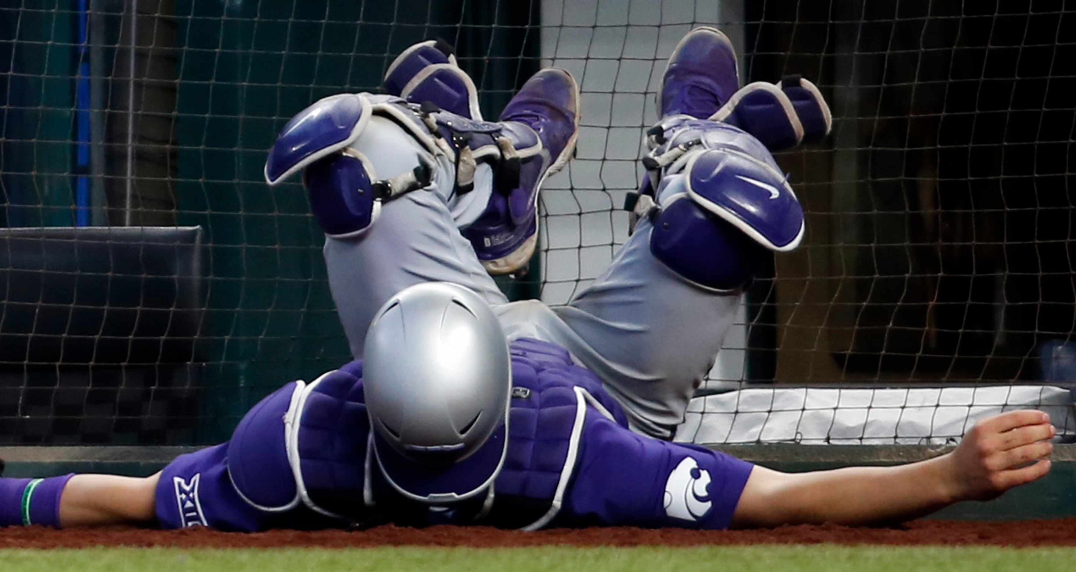 Kansas State catcher Raphael Pelletier (28) made a sliding attempt into the safety netting...