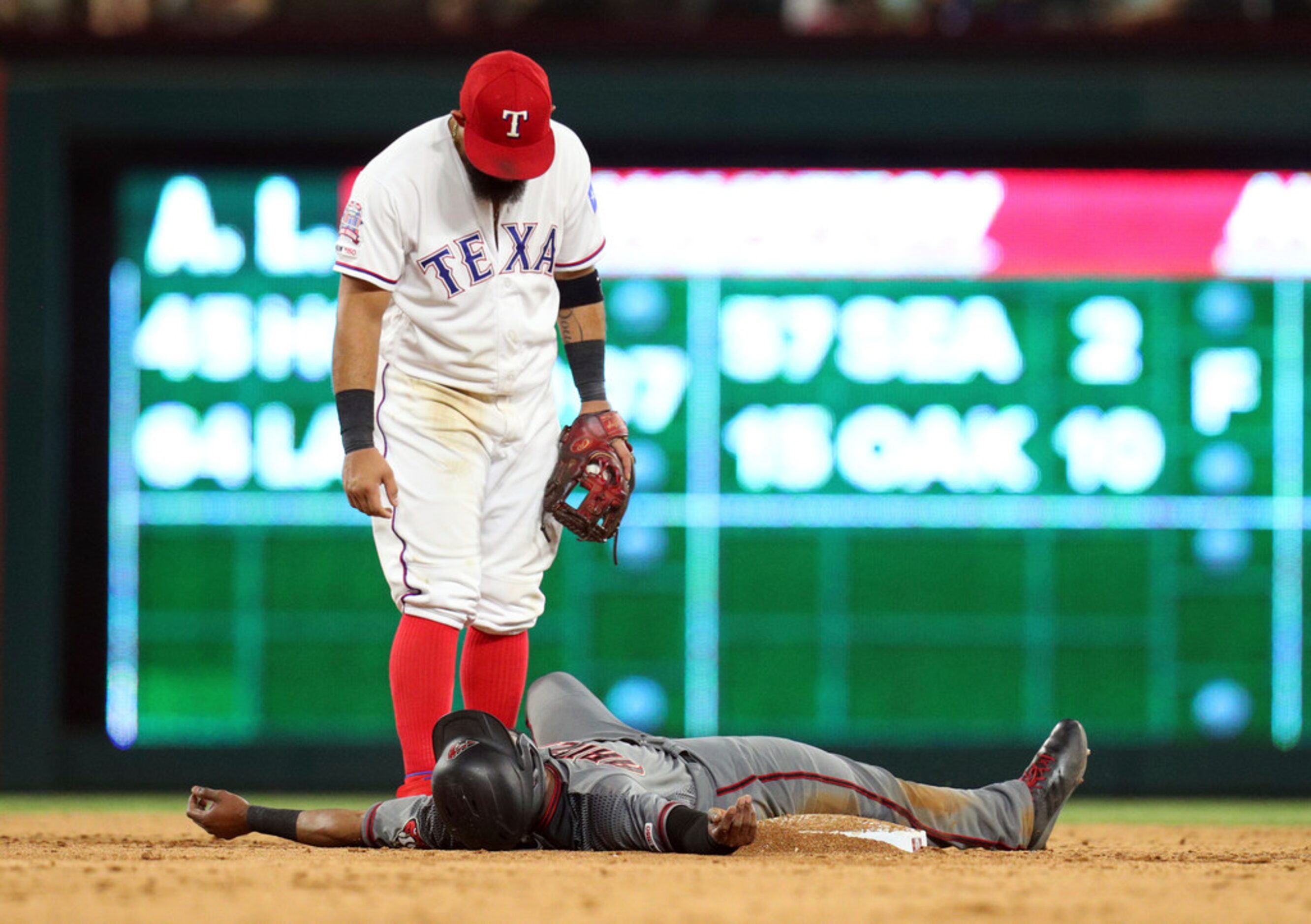 Texas Rangers second baseman Rougned Odor (12) looks down at Arizona Diamondbacks Jarrod...