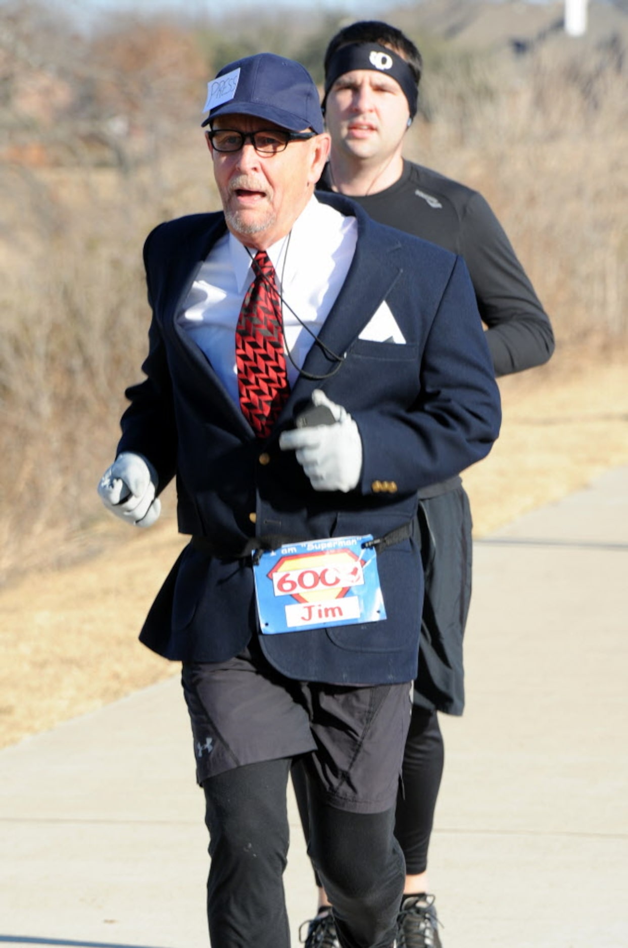 Running enthusiast, 65-year-old Jim Hardin, dressed as Clark Kent, crosses the finish line...