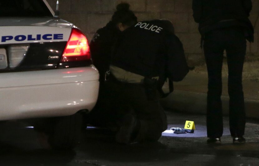 Police photograph a gun on the ground Wednesday, Dec. 24, 2014, following a shooting Tuesday...