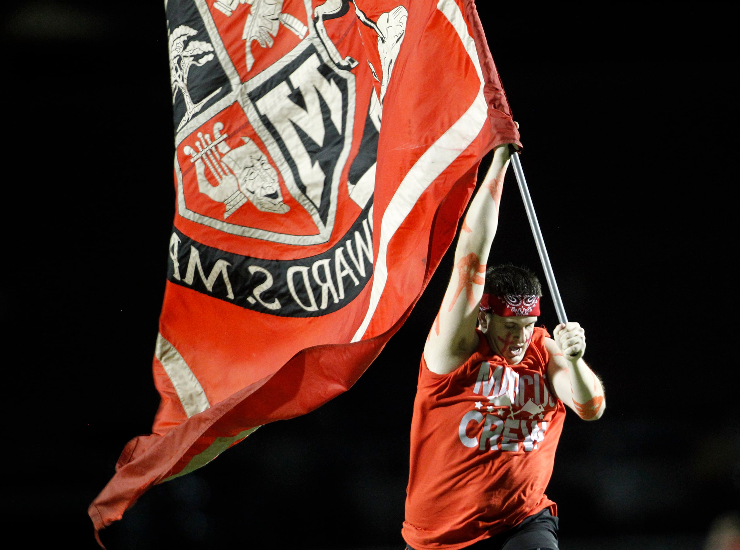 A member of the Flower Mound Marcus flag crew races across the field following a Marcus...