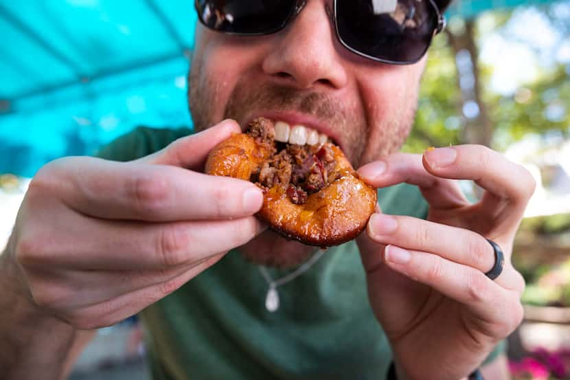 Staff writer Britton Peele digs his teeth into a Deep Fried I-35 during a taste test of the...
