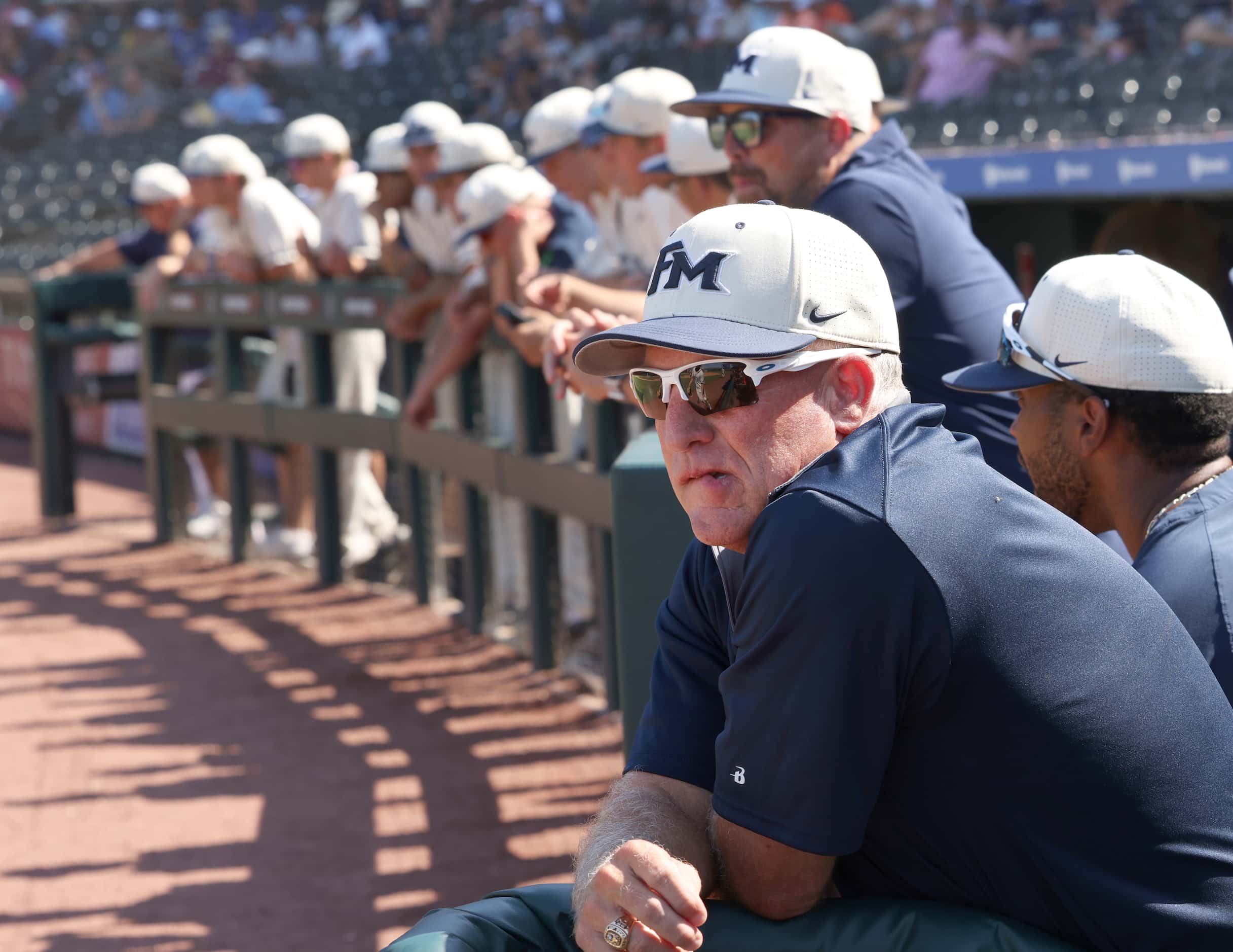 Flower Mound head coach Danny Wallace , foreground, looks on from the steps of the dugout...
