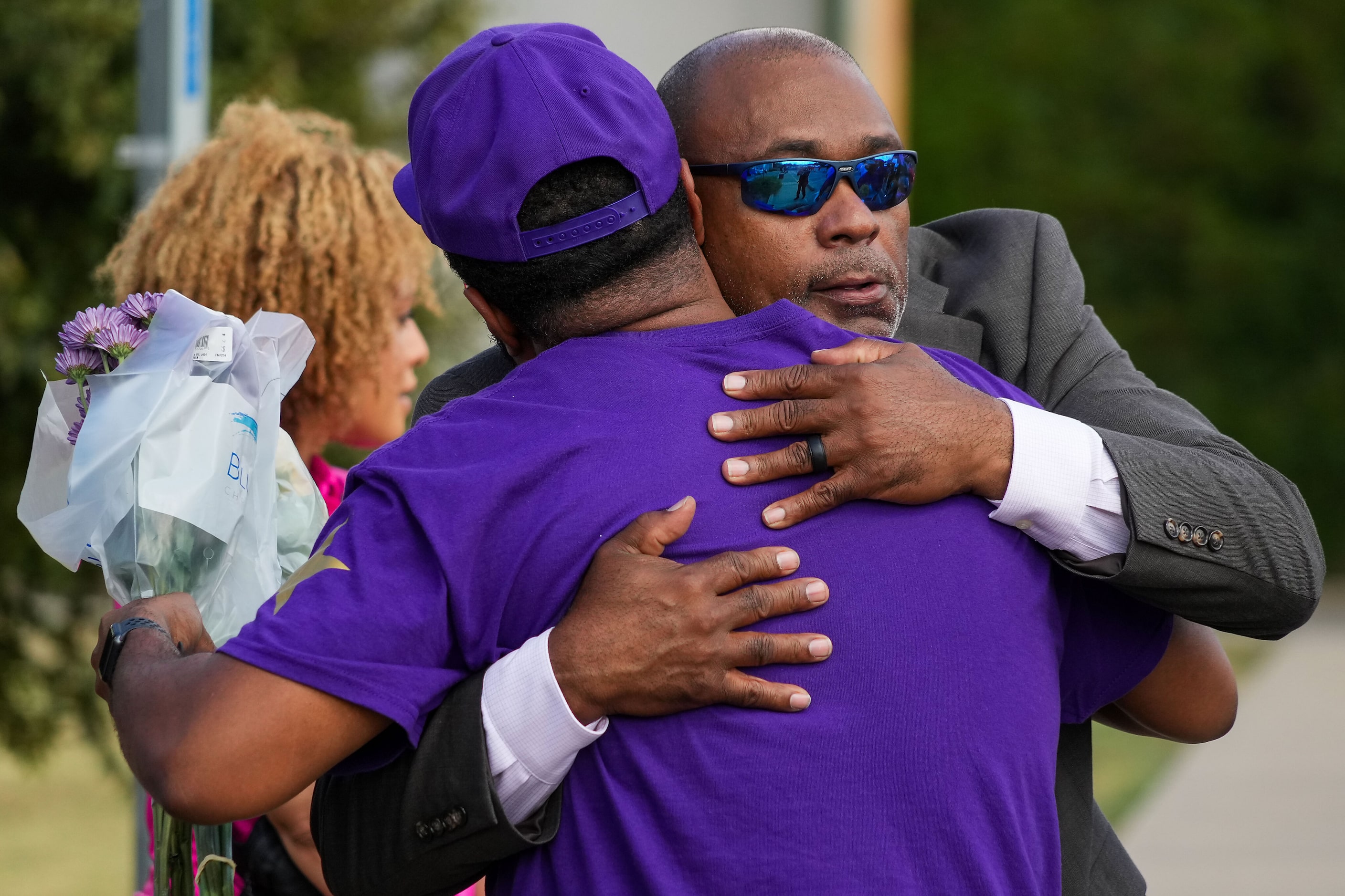 Frederick Bishop (facing) hugs a fellow fraternity brother Kenard Farr during a vigil around...