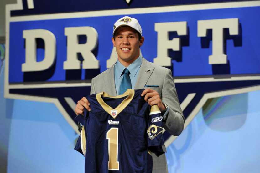 Sam Bradford smiles as he holds up a jersey after he was selected as the No. 1 overall pick...