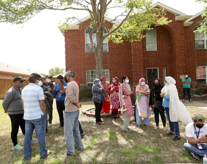 Community members gathered near the home on Pine Bluff Drive.