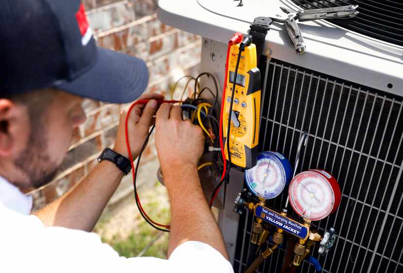 Technician Brandon Cronkhite adds refrigerant to a unit in Southlake. Should you upgrade...