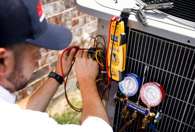 Technician Brandon Cronkhite adds refrigerant to a unit in Southlake. Should you upgrade...