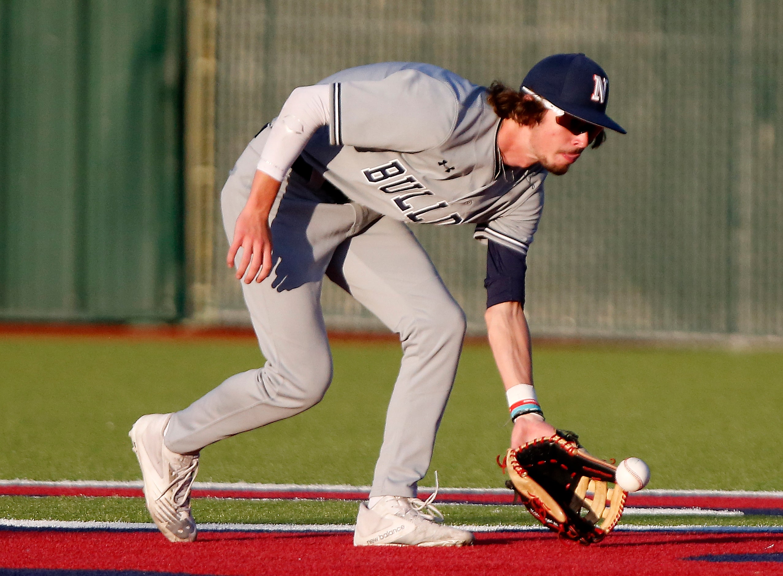 McKinney North High School center fielder Caleb Wells (8) fields a hit in the second inning...