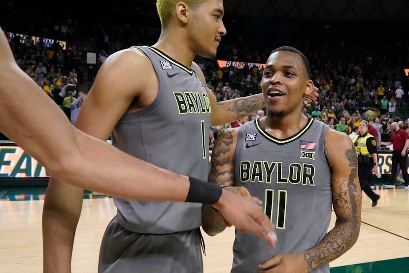 Baylor guard James Akinjo (11) is congratulated by forward Flo Thamba (0) and other...