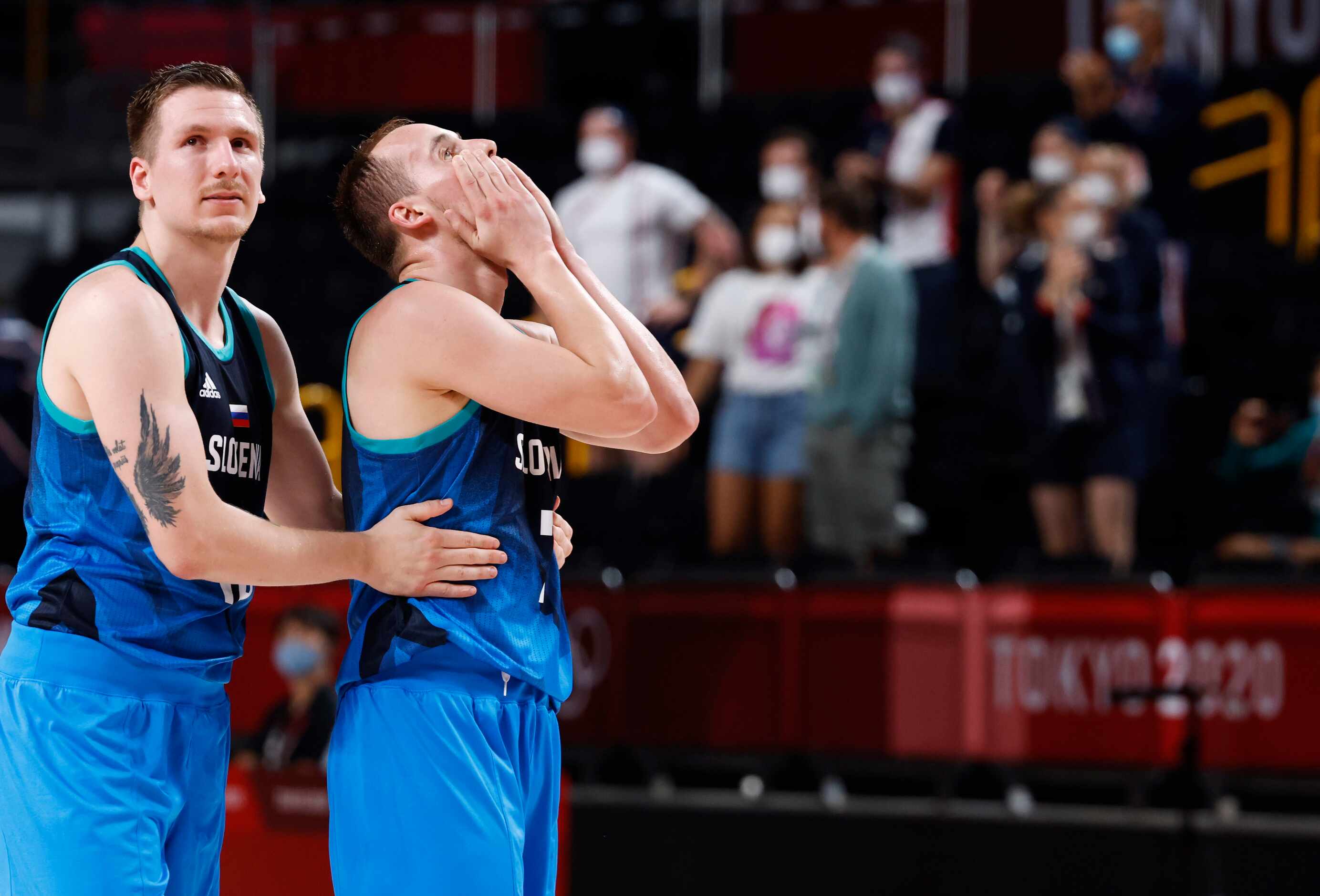 Slovenia’s Gregor Hrovat (15) consoles Slovenia’s Klemen Prepelic (7) after they lost to...