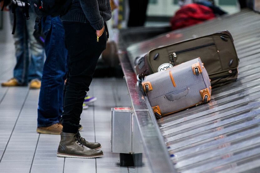 A traveler waits for his bag as luggage moves around a baggage claim at Gate C on  March 10...