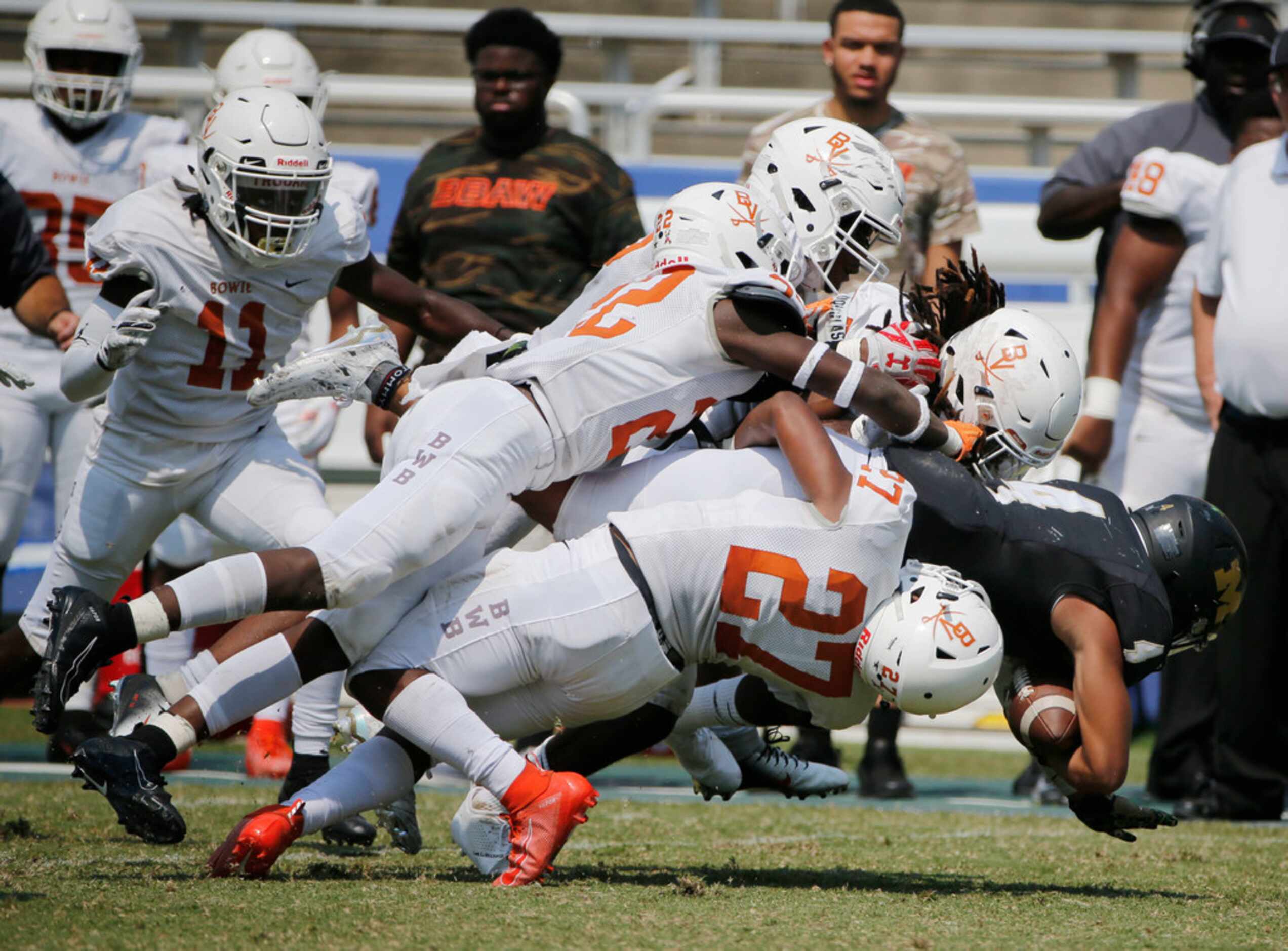 Arlington Bowie defenders gang tackle Martin running back Doneiro Davenport (4) during the...