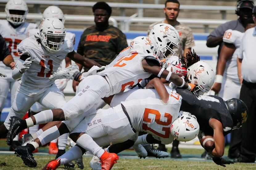 Arlington Bowie defenders gang tackle Martin running back Doneiro Davenport (4) during the...