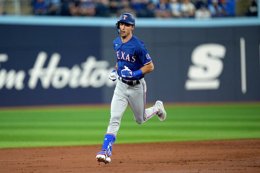 Texas Rangers' Evan Carter rounds the bases on his first career home run, a solo, during...