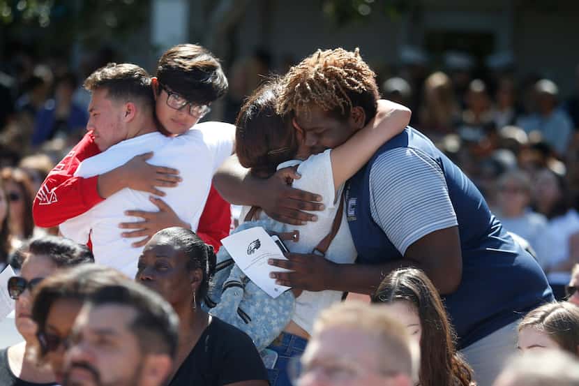 Attendees comfort each other at a prayer vigil for the victims of the shooting at Marjory...