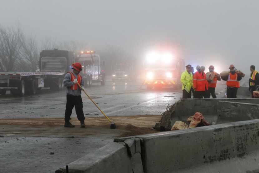 Workers cleaned up debris and fuel spills in the fog on eastbound I-30 early Friday.