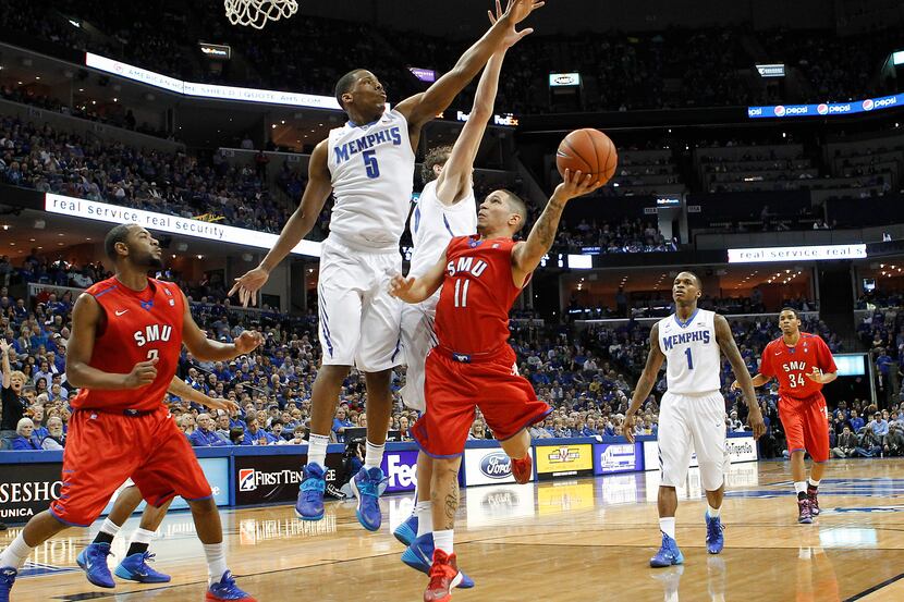 SMU guard Nic Moore (11) goes to the basket against Memphis defenders Nick King (5), Austin...