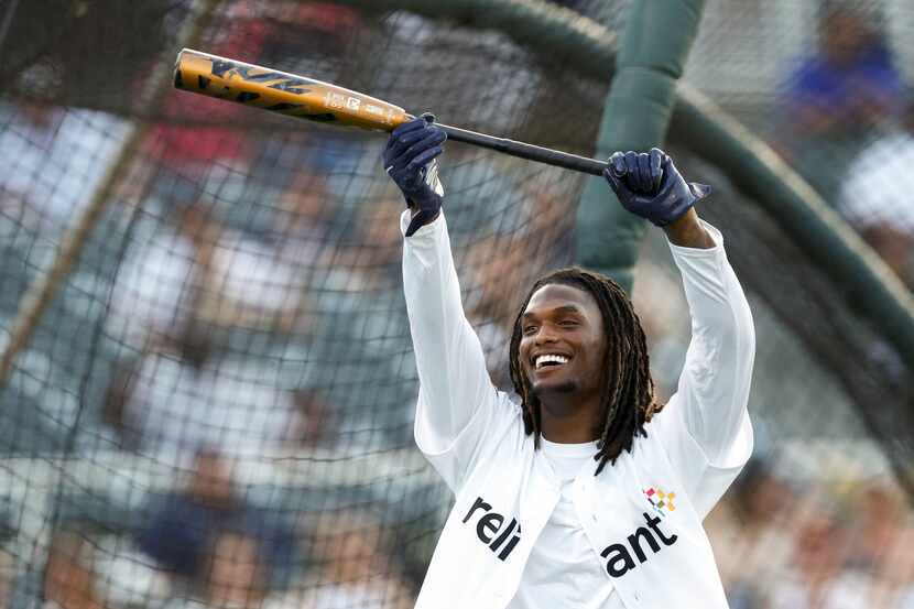 Dallas Cowboys wide receiver CeeDee Lamb raises his bat after hitting a home run during the...