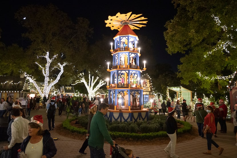 Grupos de familias se pasean por Christmas Village en la presentación de Holiday at the...