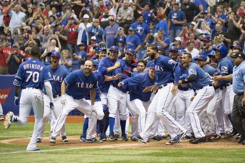 Texas Rangers' Lewis Brinson (70) celebrates his winning home run with teammates as he runs...