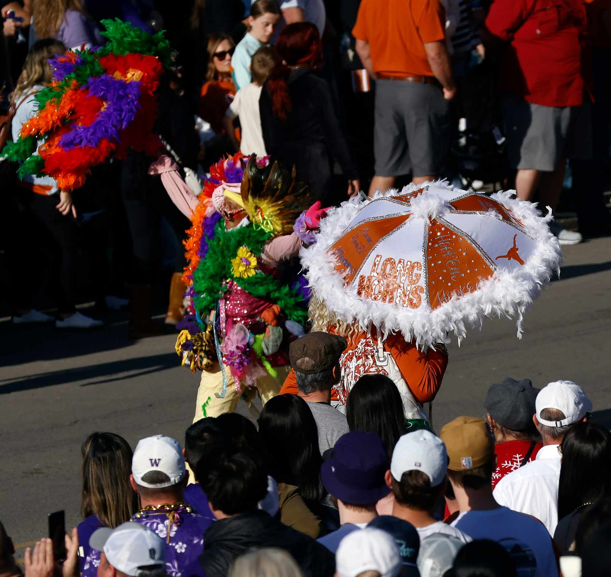 A p[air of ladies with colorful umbrellas entertain the fans before the Mardi Gras-style...
