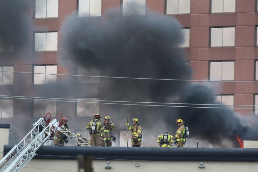 Firefighters work to extinguish a blaze at the Grand Hotel on LBJ Freeway near Coit Road in...