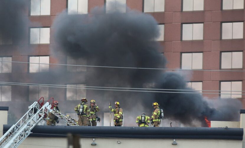 Firefighters work to extinguish a blaze at the Grand Hotel on LBJ Freeway near Coit Road in...