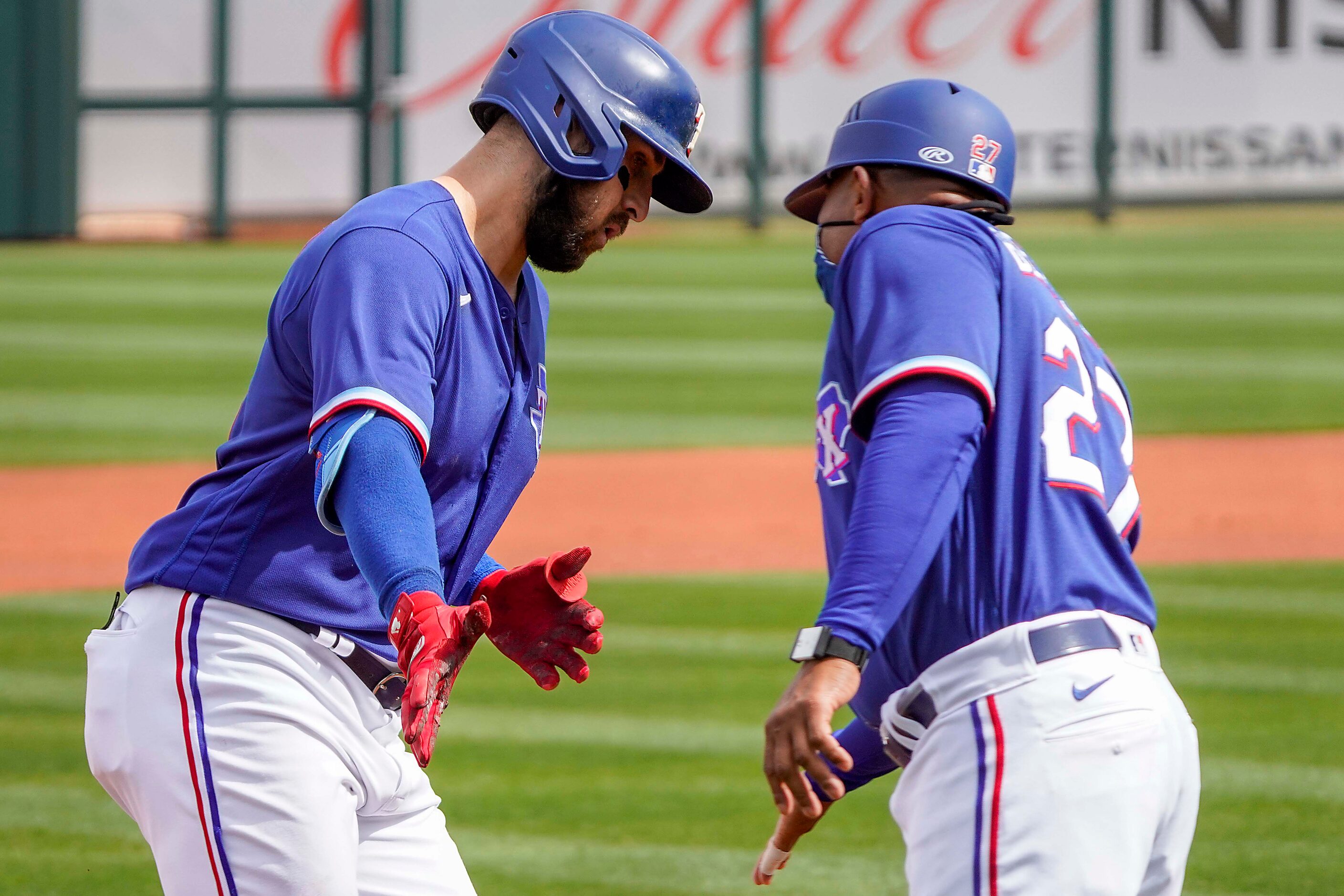 Texas Rangers outfielder Joey Gallo celebrates with third base coach Tony Beasley as he...