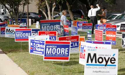 Texas House Rep. Helen Giddings and Judge Eric V. Moye handed out fliers to voters in Oak...