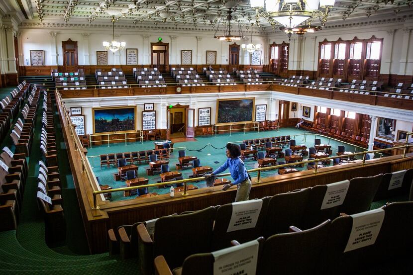 Capitol staff member Ollie Vaughn polishes the railings in the empty Texas Senate Chamber on...