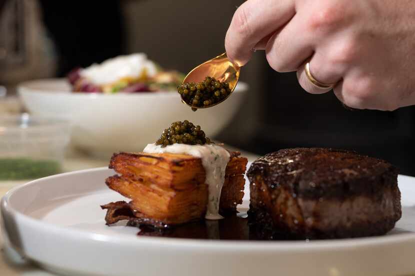 Aubrey Murphy, director of culinary for Trinity Groves, adds finishing touches to a dish of...