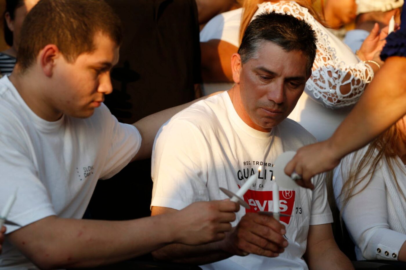 Johnny Gonzalez lights the candle of his father, Juan Gonzalez, during a memorial service...