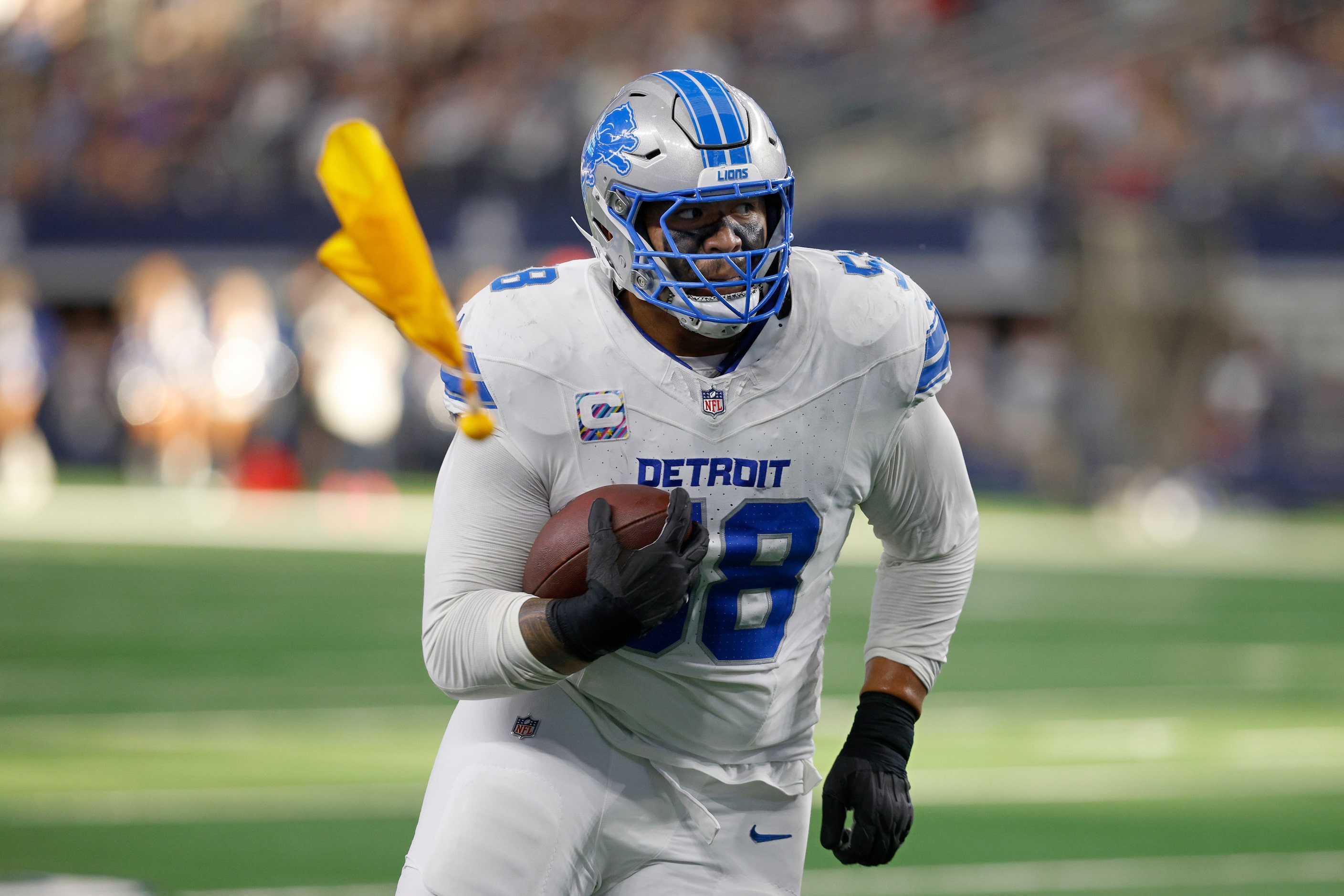 A penalty flag flies as Detroit Lions offensive tackle Penei Sewell (58) runs into the end...