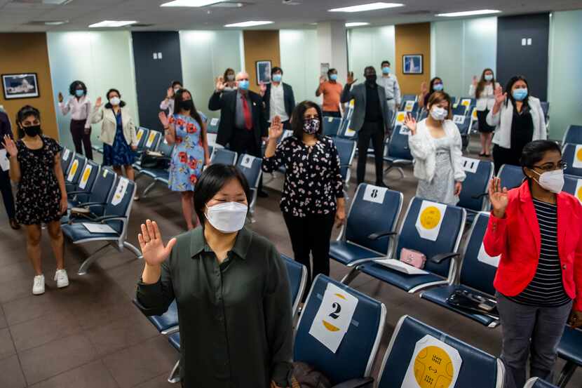 Rebecca Taehee Lee (front) joined others in taking an oath of citizenship during a...