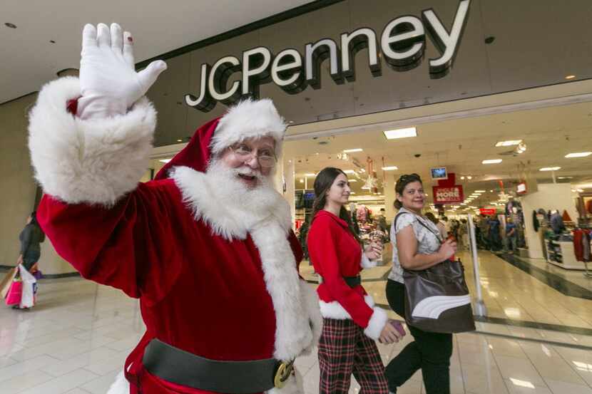 FILE - In this Nov. 28, 2014 file photo, a man dressed as Santa Claus greets shoppers...