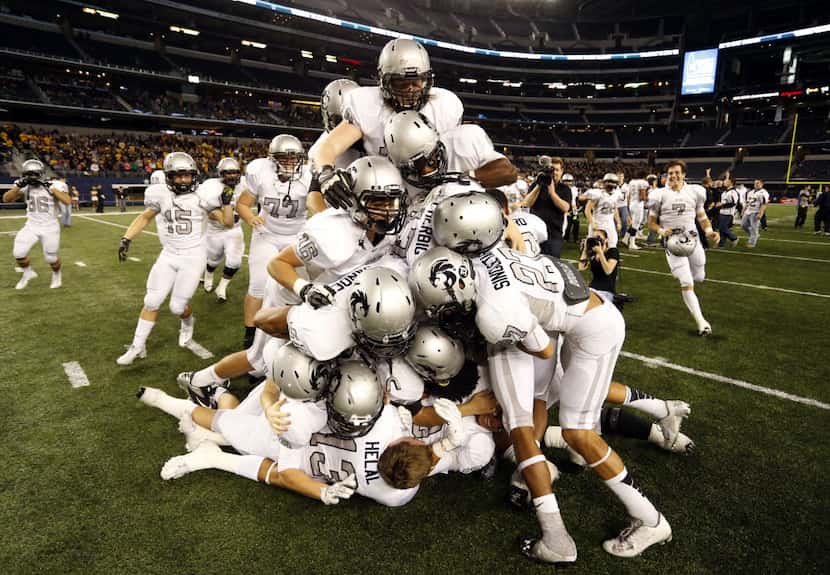 The Denton Guyer High football team piles up on each other after their 31-14 win in the UIL...