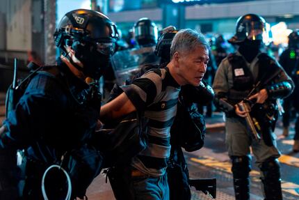 A man is escorted by the police after a pro-democracy rally in the Mong Kok district in Hong...