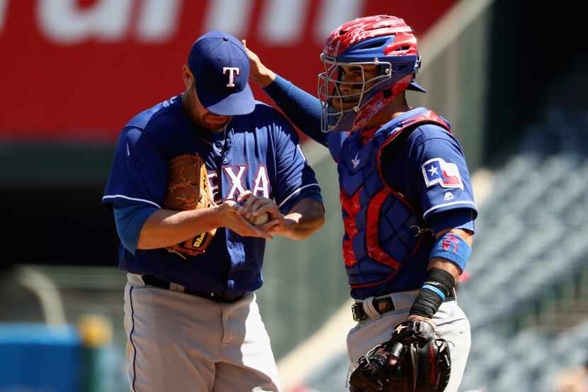 ANAHEIM, CA - SEPTEMBER 11:  Colby Lewis #48 and Robinson Chirinos #61 of the Texas Rangers...