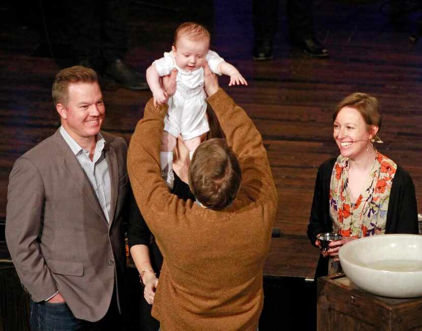 Rasmussen lifts baby Cash Michael LaRose  in joy before his baptism at the Cornerstone...