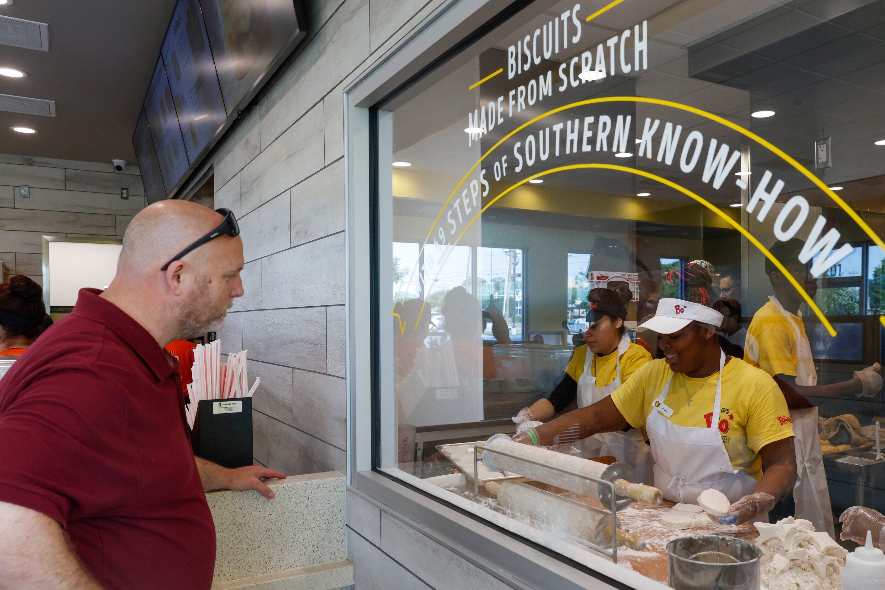 Patrick Sheline (left) watches Bojangles employee J’naria Coffey preparing biscuits from...