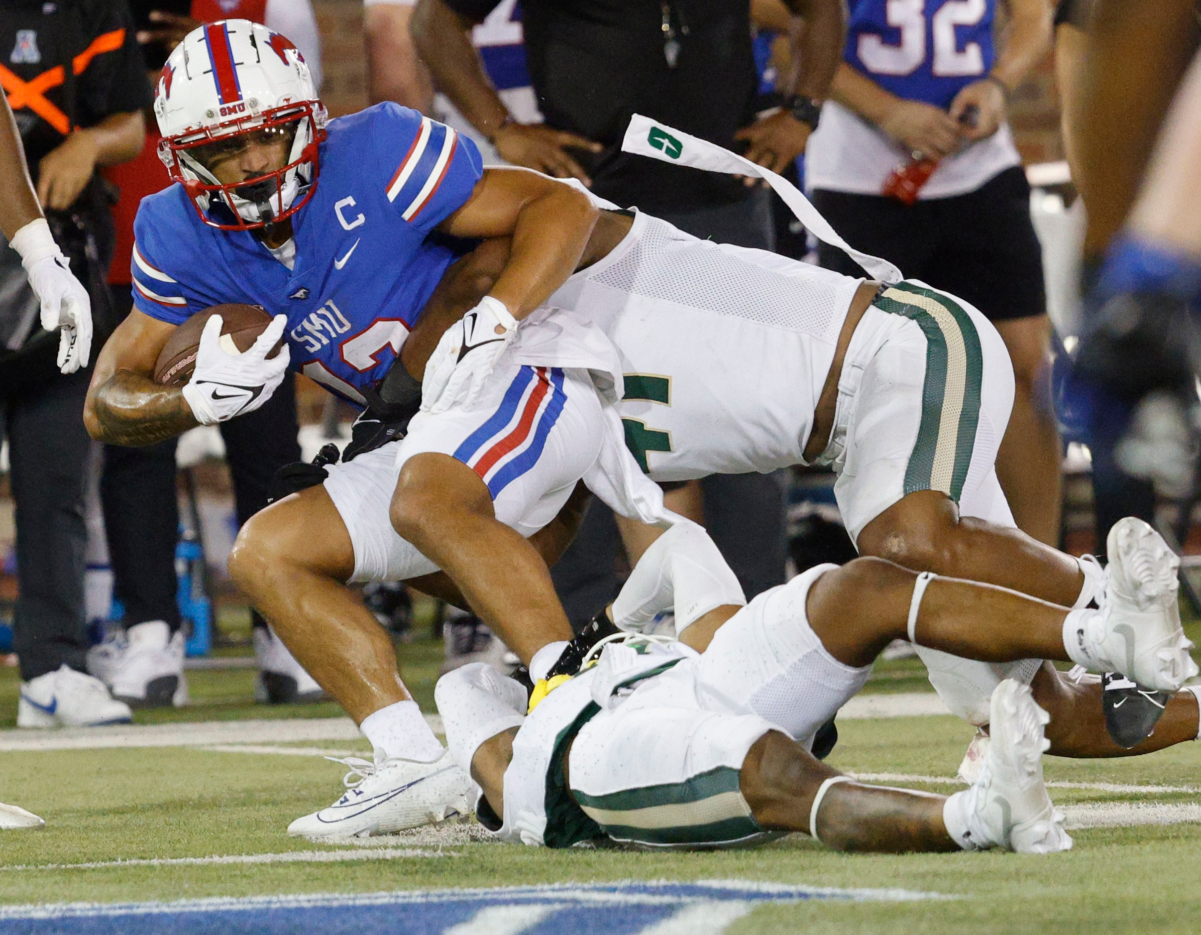 SMU wide receiver Jake Bailey (12) is tackled by Charlotte 49ers defensive back C.J. Burton...