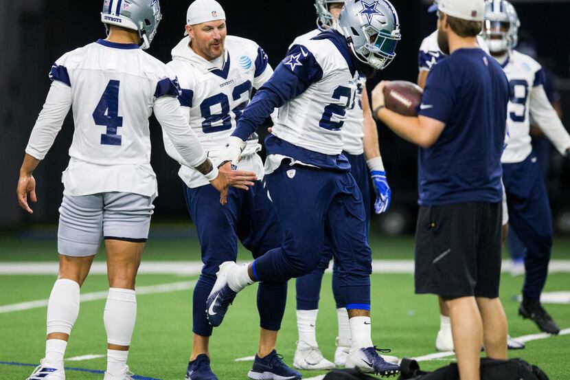 Dallas Cowboys running back Ezekiel Elliott (21) gets high-fives from quarterback Dak...