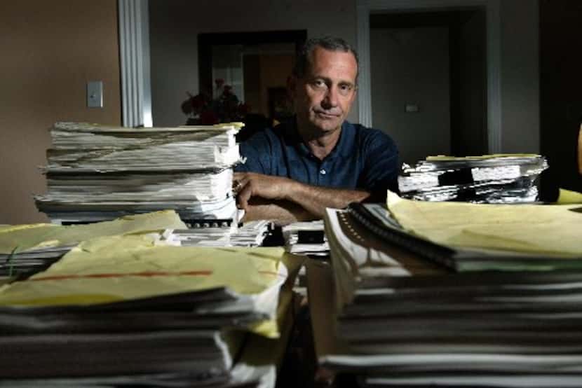 Former Dallas firefighter Joe Bob Betzel is surrounded in his Midlothian home by paperwork...
