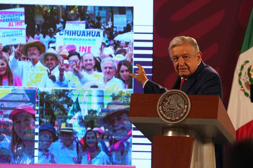 Mexican President Andres Manuel Lopez Obrador points to photos of the previous day's protest...
