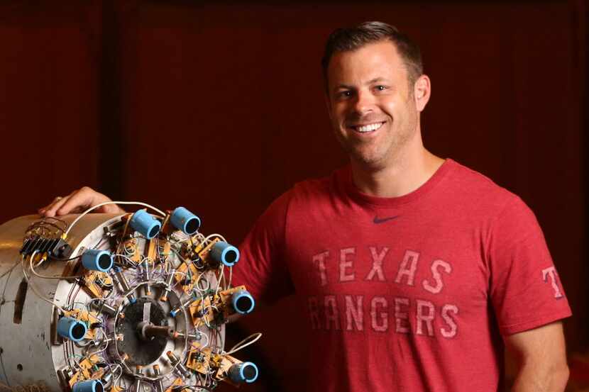 Brad Hunstable stands next to an early prototype of a next generation electric motor he...