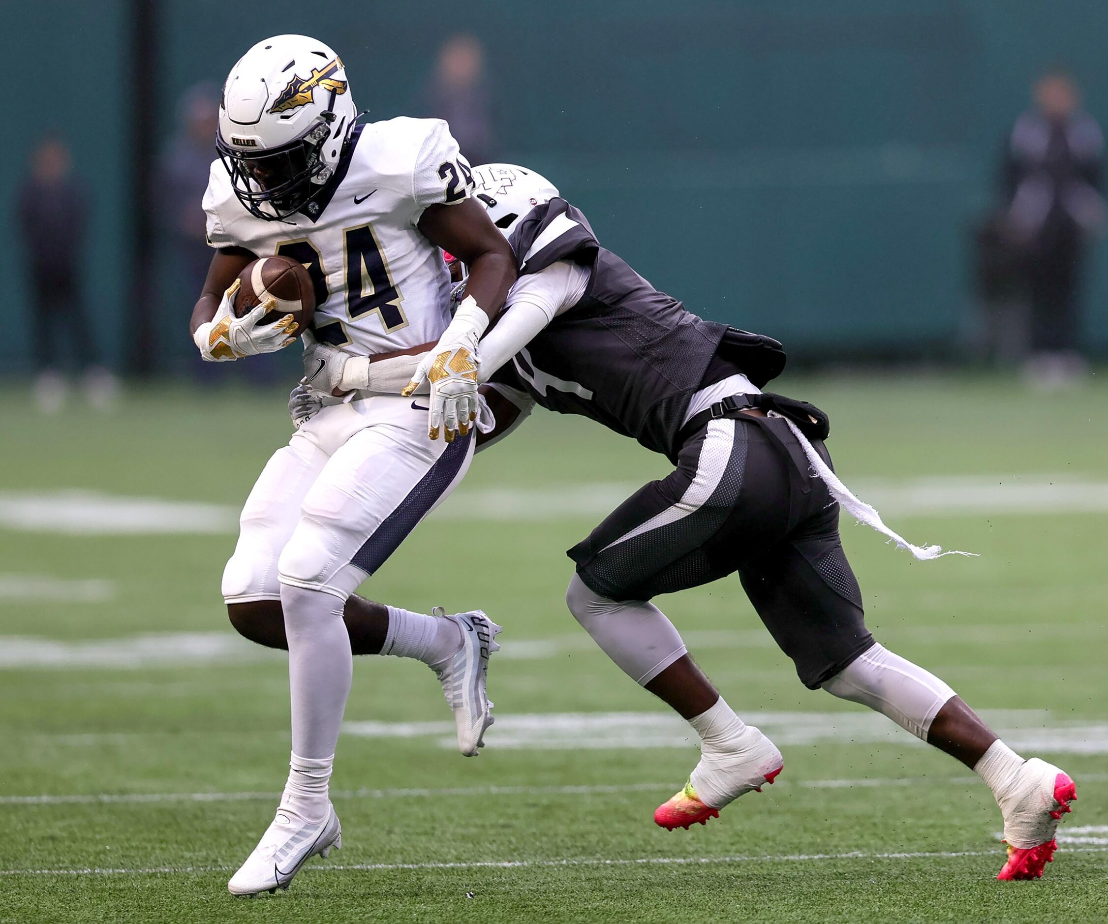 Keller running back Cameron Rayford (24) tries to break free from the tackle of Lewisville...