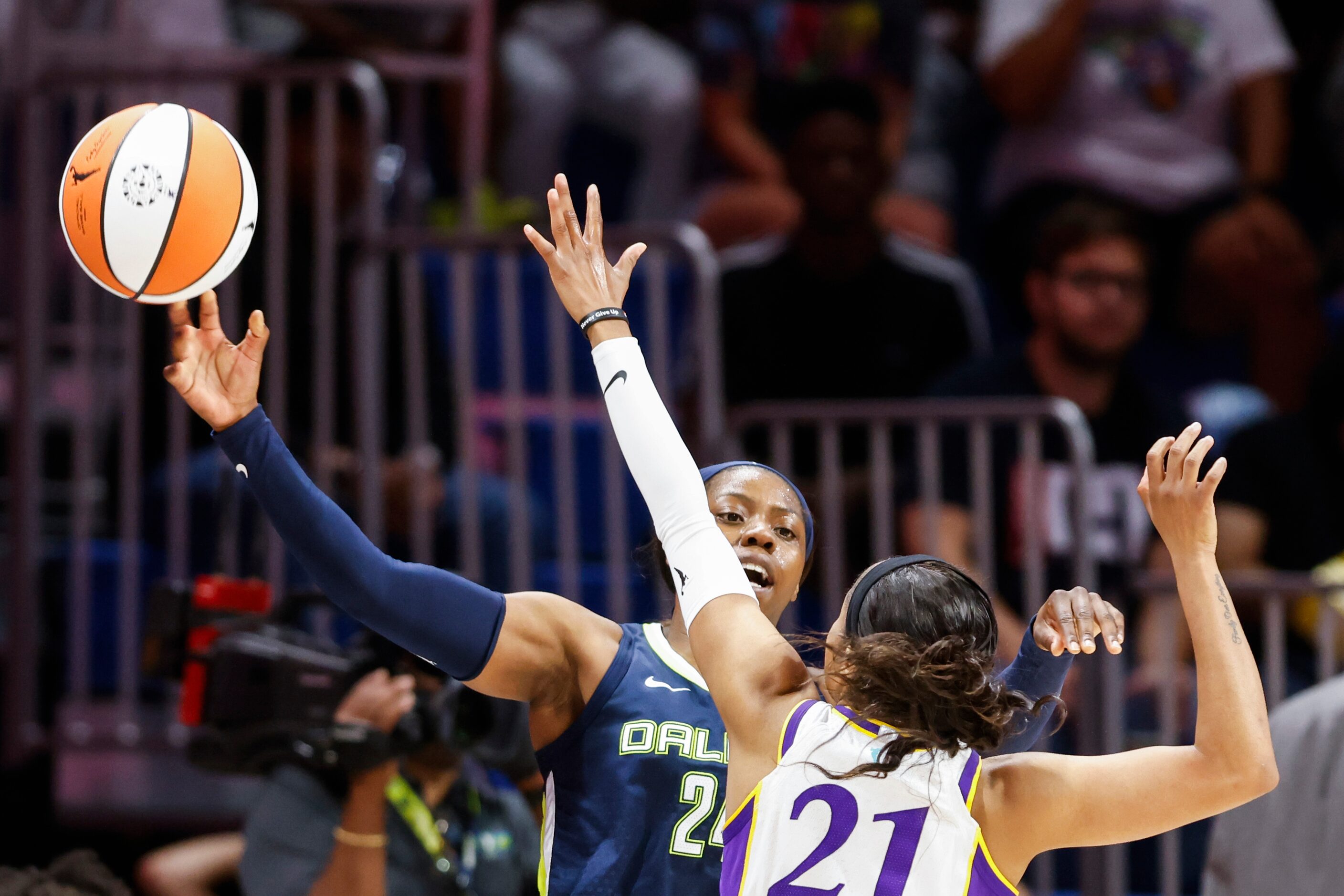 Dallas Wings guard Arike Ogunbowale, back, passes the ball as Los Angeles Sparks guard...