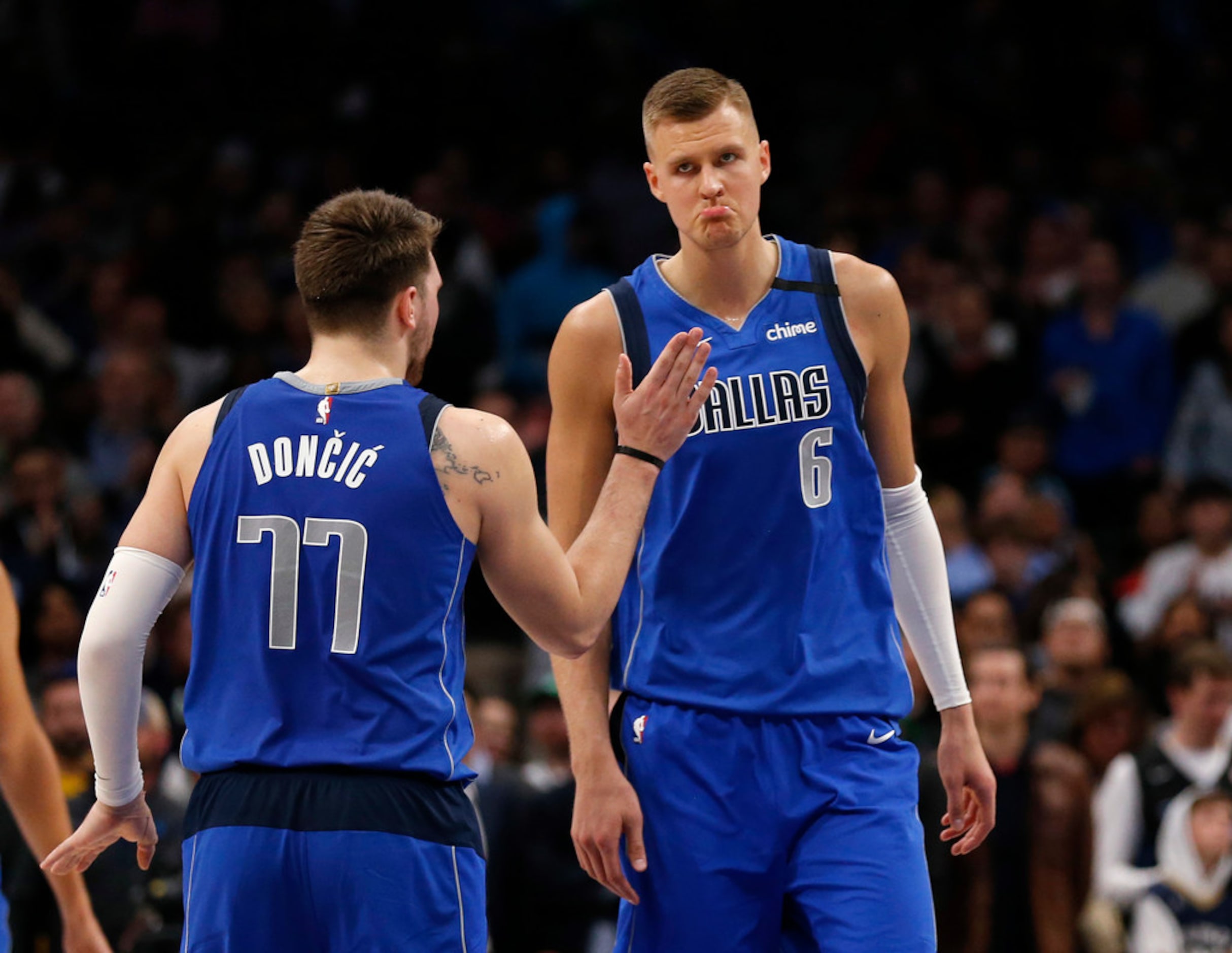 Dallas Mavericks guard Luka Doncic (77) taps Dallas Mavericks forward Kristaps Porzingis (6)...